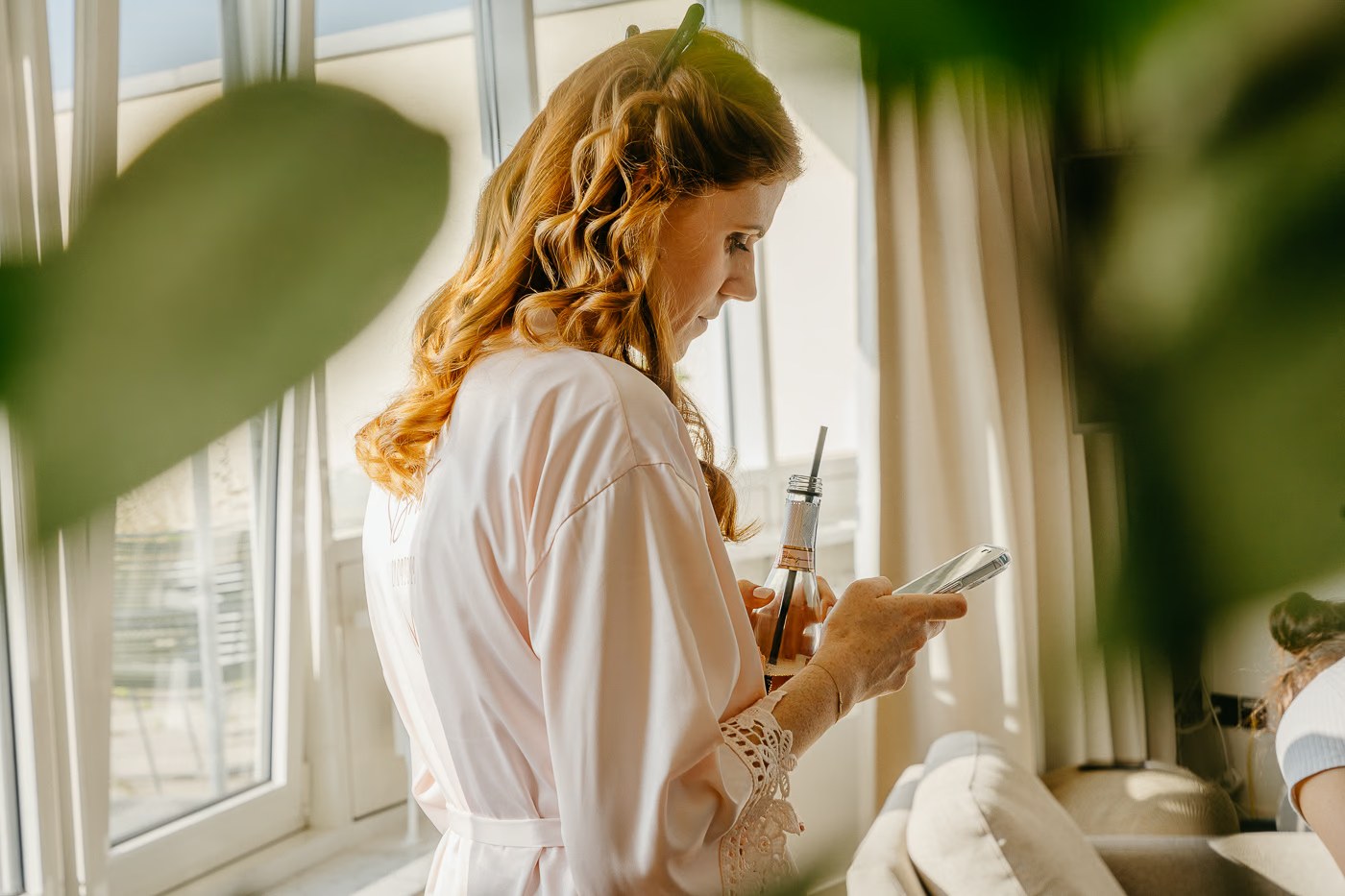 Getting Ready Hochzeit – Braut im Morgenmantel am Fenster mit Sekt, goldenes Licht, stimmungsvolle Hochzeitsfotografie Schöningen Kathrin Skorpel