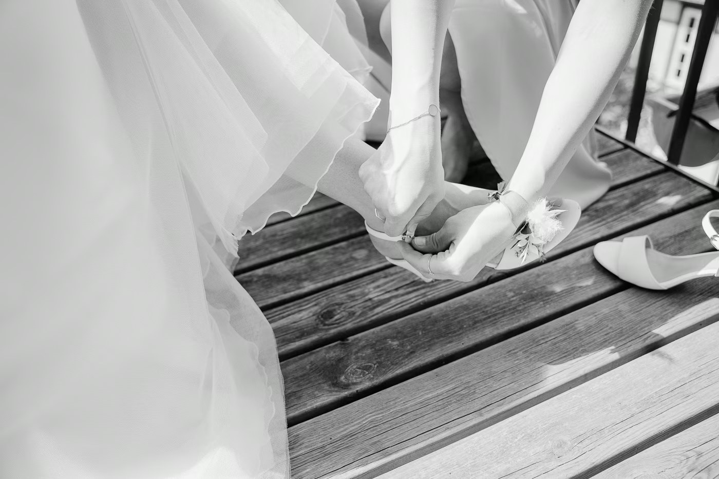 Getting Ready Hochzeit – Brautschuhe werden angezogen, Schleier liegt auf dem Holzboden, stimmungsvolle Schwarz-Weiß Hochzeitsfotos Wolfenbüttel Kathrin Skorpel