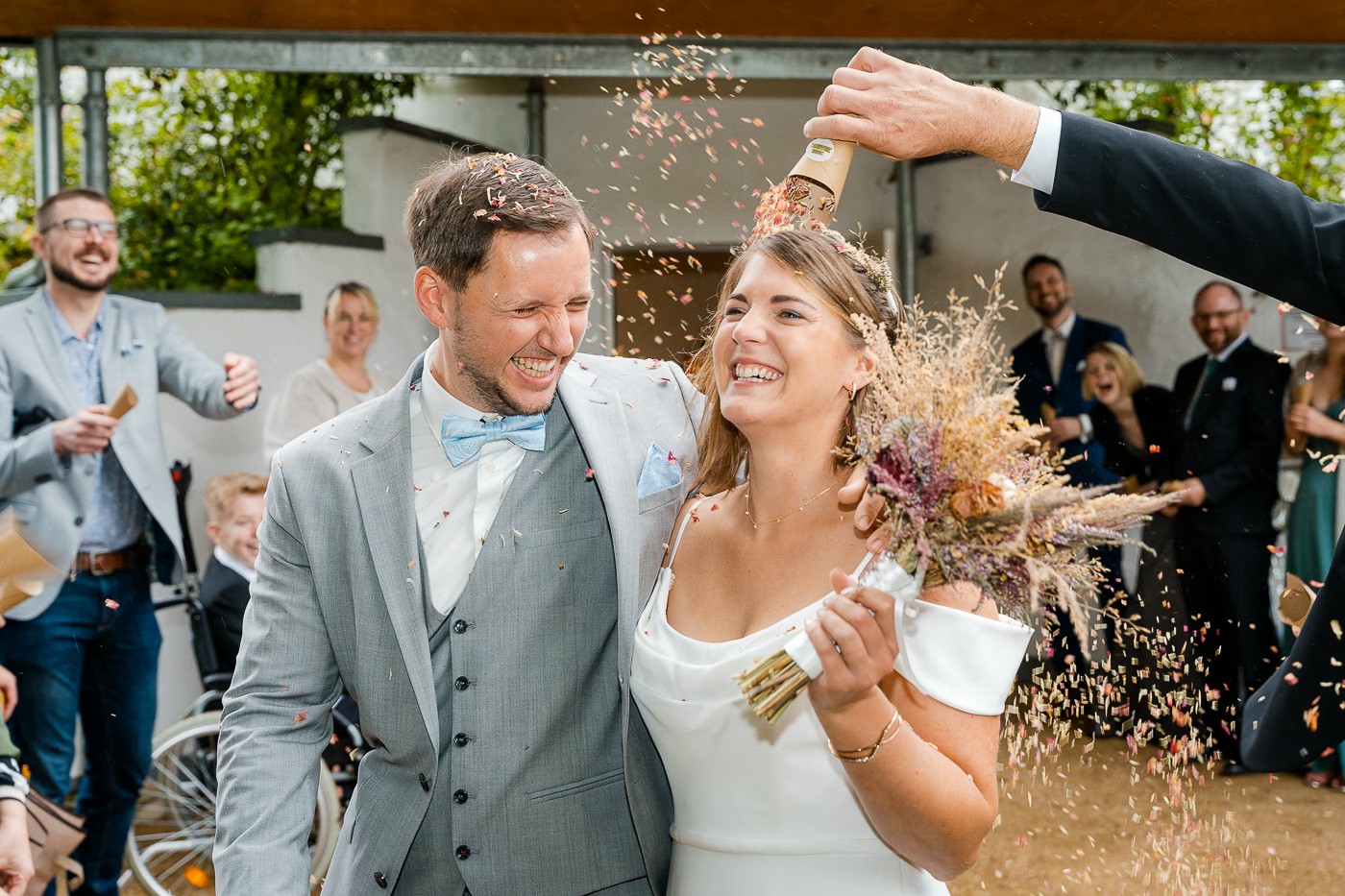 Hochzeitsfeier Hochzeitsmühle Gifhorn – Brautpaar beim Auszug, Gäste gratulieren und jubeln, ausgelassene Stimmung direkt nach der Trauung, Hochzeitsfotografie Hochzeitsmühle Gifhorn Kathrin Skorpel