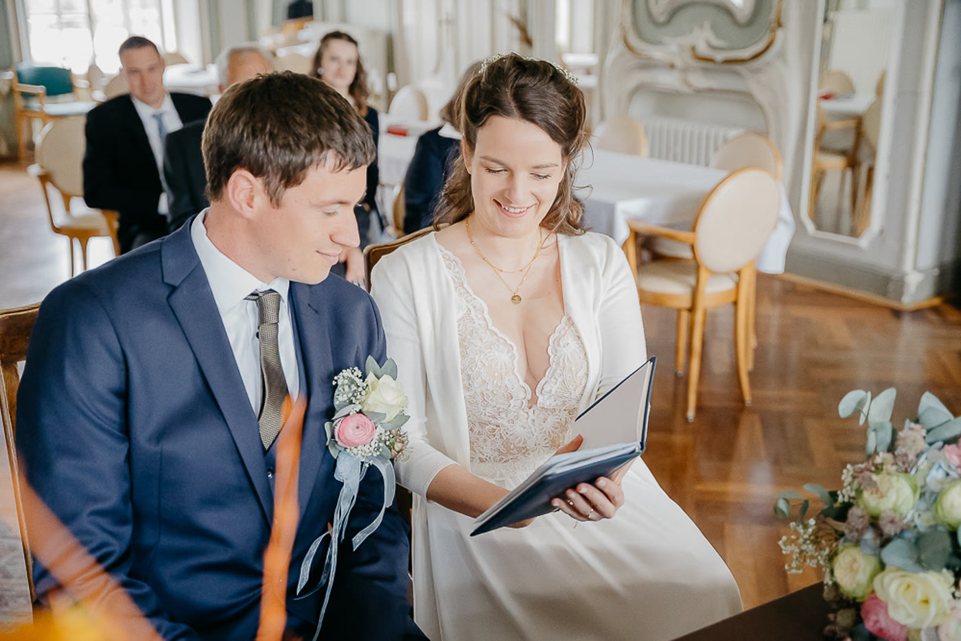 Standesamt Hochzeit Braunschweig – Brautpaar schaut lächelnd gemeinsam in die Heiratsurkunde im prachtvollen Rokokosaal, ein leiser Moment nach dem Ja-Wort, Hochzeitsreportage Braunschweig Kathrin Skorpel