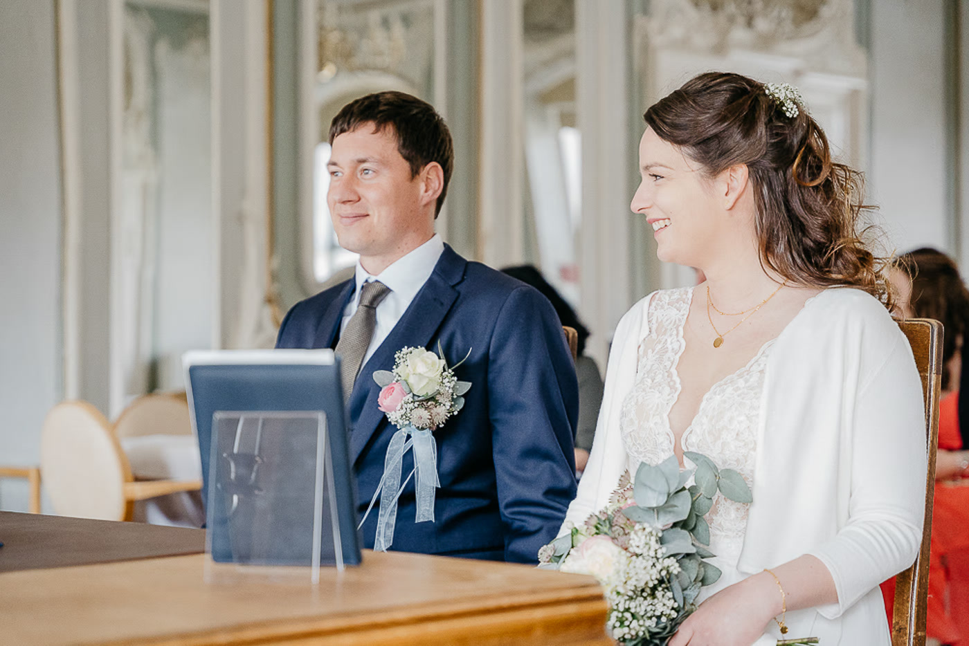 Standesamt Hochzeit Wolfsburg – Brautpaar sitzt nebeneinander im historischen Rokoko-Trausaal und lächelt, heller Lichteinfall, gelöste Stimmung beim standesamtlichen Ja-Wort, Hochzeitsfotografie Wolfsburg Kathrin Skorpel
