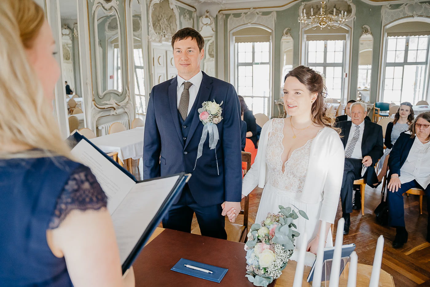 Standesamt Hochzeit Braunschweig – Brautpaar steht vor der Standesbeamtin im prachtvollen Rokoko-Trausaal mit goldenen Stuckverzierungen und großen Fenstern, Hochzeitsreportage Braunschweig Kathrin Skorpel
